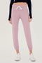 Front view of woman wearing light pink sweatpant jogger with white drawstring and black turtleneck cropped long sleeve paired with white shoes