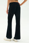 A person wearing SPLITS59 Blaire Rib Pant in black, made with soft modal and spandex, paired with white sneakers, stands on a white background, shown from the back waist down.
