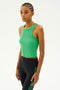 A person wearing the Kiki Rib Crop - Grass from SPLITS59 and black pants with green stripes stands against a plain background.