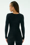 A person with braided hair wears the SPLITS59 Chloe Airweight Jumpsuit in black, made from soft Airweight fabric, standing against a plain light background.