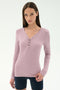 A woman with straight brown hair wears the SPLITS59 Louise Rib Henley in Blush and dark shorts, standing against a plain light background.
