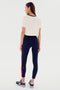 A person wearing a relaxed fit Djuna Crop Ringer - White/Indigo by SPLITS59 and navy athletic leggings with a single red stripe stands facing away, showing the back view of the outfit. Ideal for warm weather workouts, they also sport black and white athletic shoes.