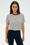 A person wearing the SPLITS59 Djuna Crop Ringer in Indigo Stripe and dark leggings stands against a plain background, ready for gym workouts.