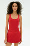 A woman with curly hair wears the SPLITS59 Martina Rigor Dress in Pirate Red, standing against a plain white background.