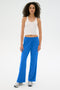 A person in a white tank top and SPLITS59's Maxie Rigor Track Pant - Classic Blue/White with sneakers stands against a white background.
