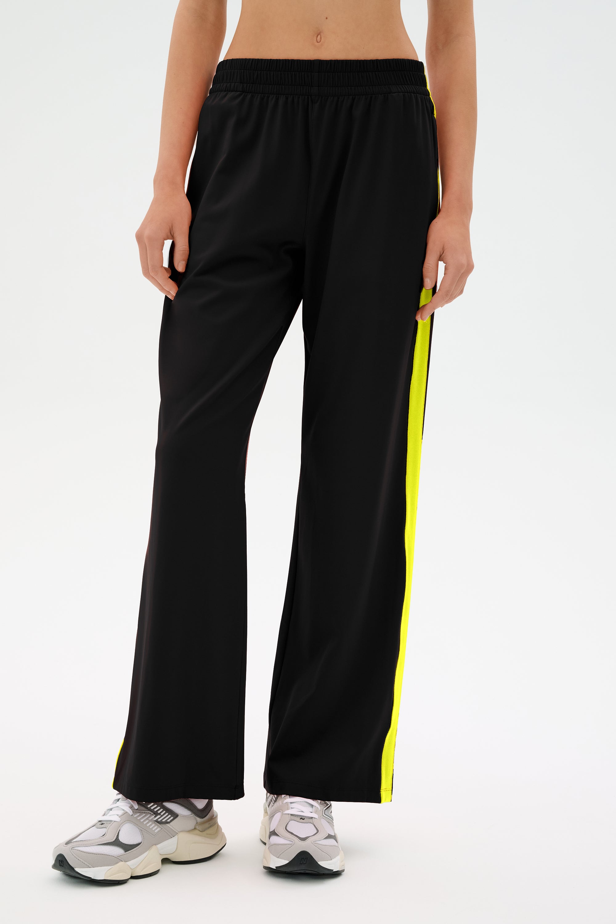 A person wearing the SPLITS59 Maxie Rigor Track Pant with gray sneakers stands against a plain background.