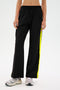 A person wearing the SPLITS59 Maxie Rigor Track Pant with gray sneakers stands against a plain background.