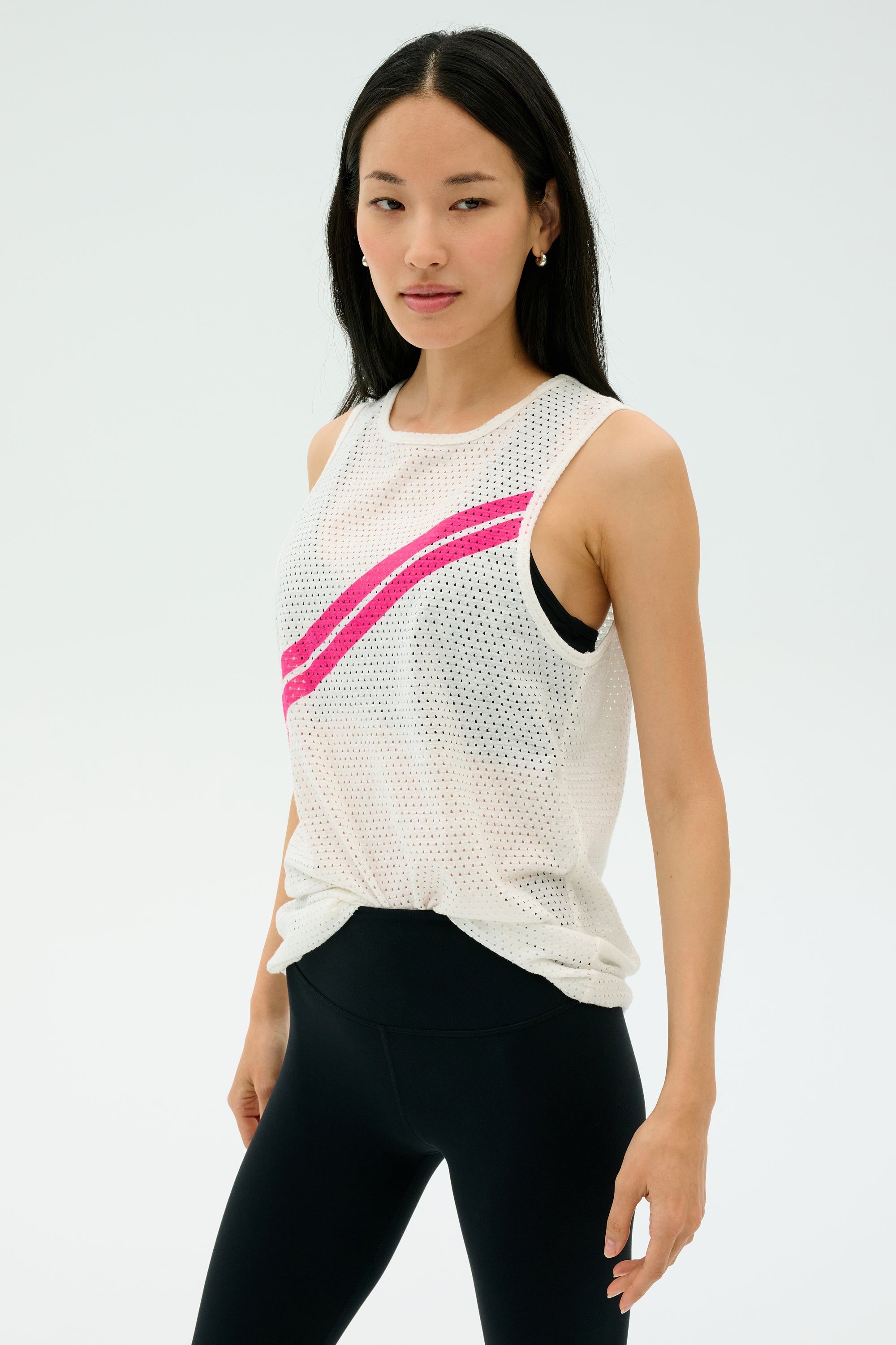 A woman wears the SPLITS59 Bandit Mesh Tank in White/Berry with black leggings, standing against a plain light background.