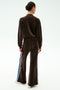Person faces away from the camera wearing SPLITS59’s Heritage Velour Pant in Dark Chocolate/Classic Blue, a flared wide-leg style with side stripes, set against a plain white background.