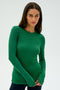 A person wearing the SPLITS59 Louise Rib Long Sleeve in Arugula stands against a plain background, showcasing the sleek comfort of spandex.
