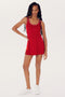 Person in a red sleeveless SPLITS59 Martina Rigor Dress w/Piping - Pirate Red and white sneakers, standing against a plain white background.