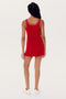 Person wearing a red sleeveless SPLITS59 Martina Rigor Dress w/Piping - Pirate Red, paired with white sneakers, facing away from the camera.