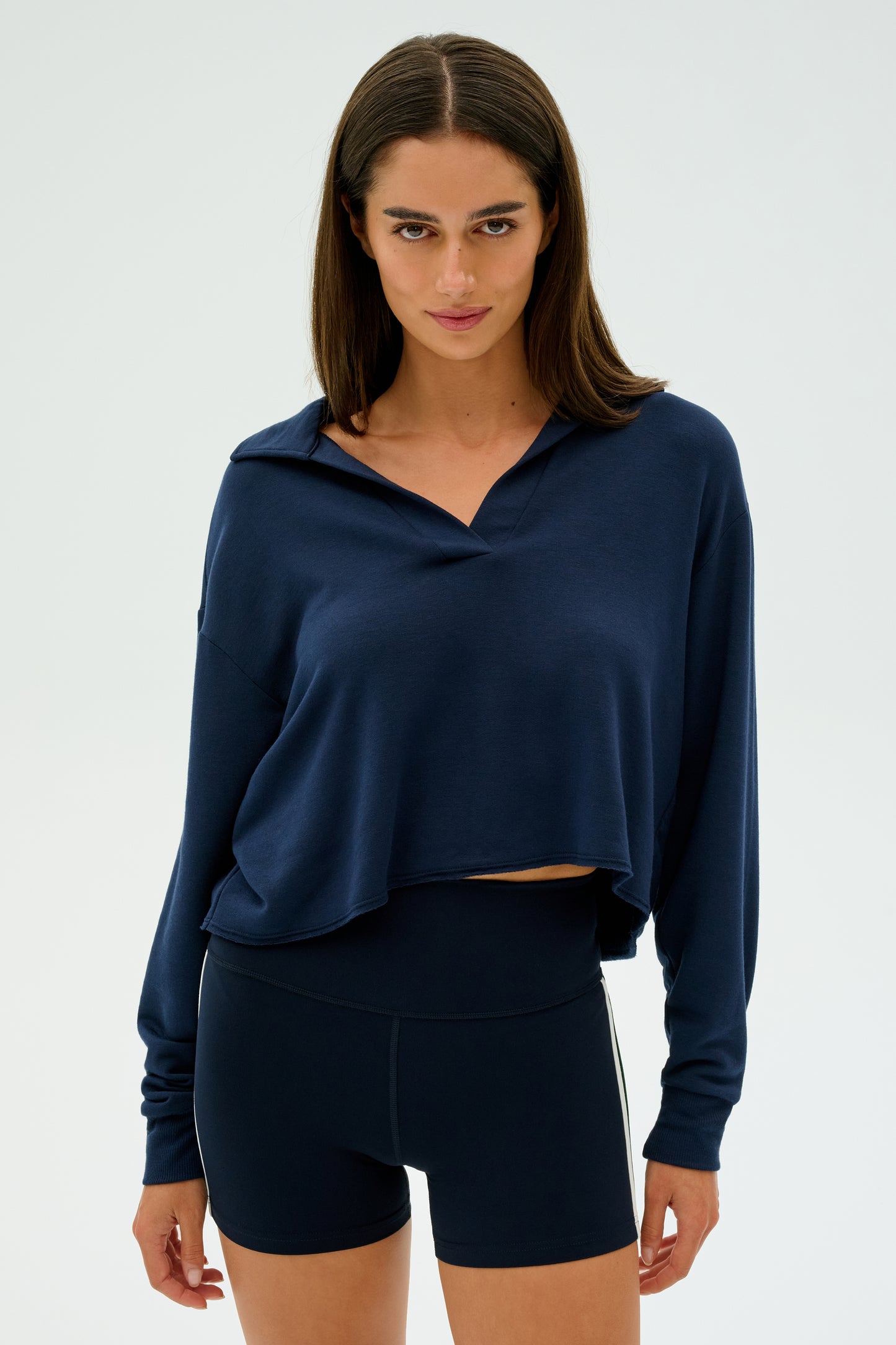 Person wearing the SPLITS59 Joan Fleece Polo Sweatshirt in navy with matching shorts, standing against a plain background.