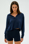 Person wearing the SPLITS59 Joan Fleece Polo Sweatshirt in navy with matching shorts, standing against a plain background.