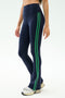A person wears SPLITS59 Raquel High Waist Supplex Flare leggings in Indigo/Grass—navy with two green side stripes—paired with white sneakers, shown waist to feet. These 4-way stretch leggings are ideal for workouts or casual wear.