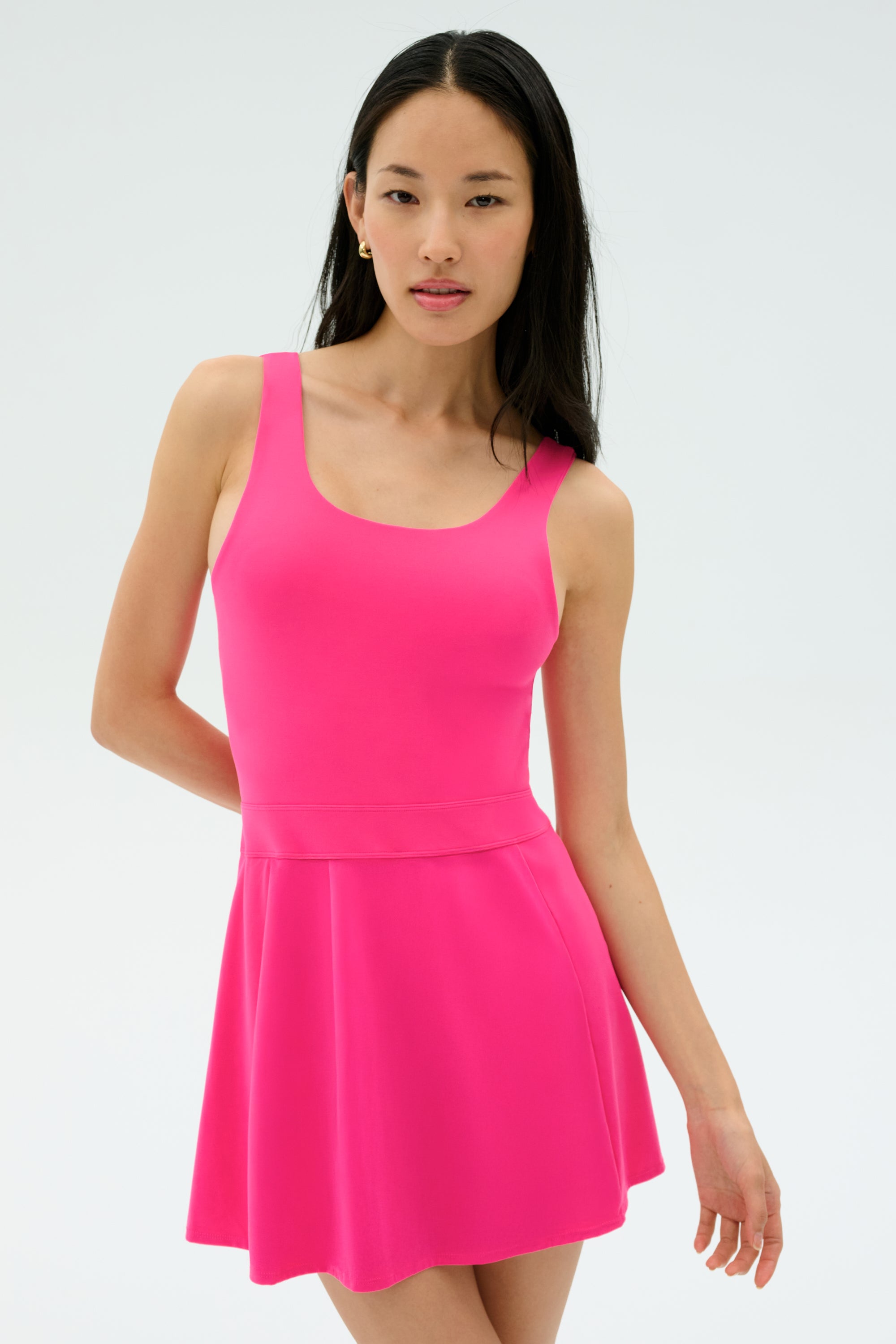 A woman wearing the SPLITS59 Martina Rigor Dress in Berry stands against a plain light background, looking at the camera.