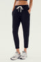 A person wearing the Reena Fleece 7/8 Sweatpant in Black by Splits59, paired with gray sneakers, epitomizes comfort and style.