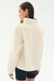 A woman with straight brown hair is seen from the back in a SPLITS59 Harris Sherpa Jacket in Creme/Indigo and dark shorts, against a plain white background.