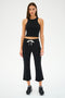 A person models comfy chic in SPLITS59's Brooks Fleece Cropped Flare - Black and a sleeveless top, paired with black sneakers featuring white soles, on a plain white backdrop.