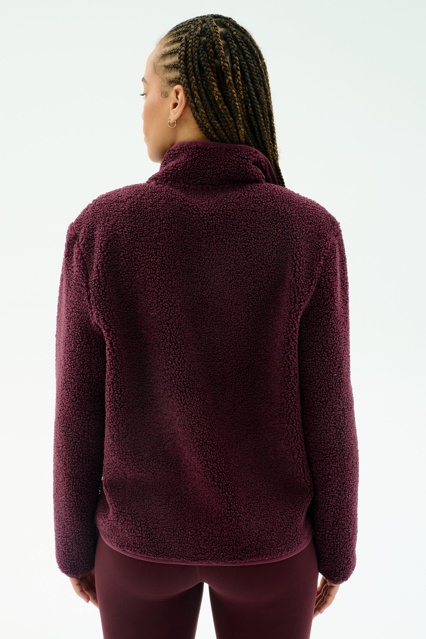 Individual with braided hair wears the SPLITS59 Harris Sherpa Jacket in Dark Cherry, crafted from soft polyester, seen from the back against a plain light background.