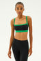 A person wearing the Monah Rigor Bra in black and grass from SPLITS59 sports a sleek spandex ensemble against a plain background.