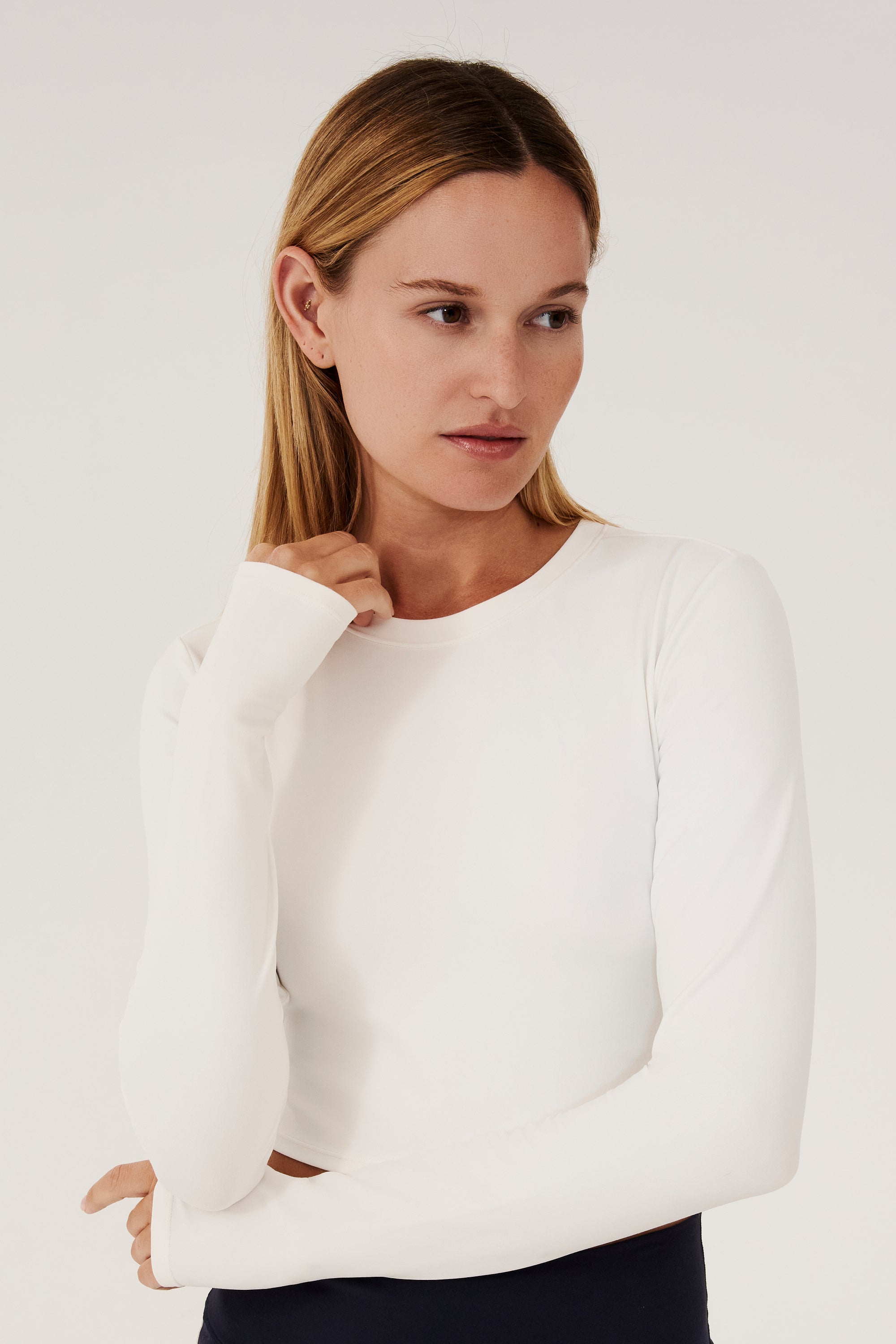 Front view of girl wearing white long sleeve crop top and black leggings with white stripe