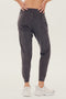 Back view of girl wearing dark grey sweatpants with black tie around waistband with white shoes 