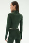 A woman wearing the SPLITS59 Stevie Active Rib Half Zip in Heather Military, shown from the back against a plain light background.