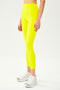 Front view of model wearing bright yellow high waist  leggings and white shoes