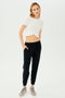 A woman wearing black high waist leggings and a white SPLITS59 Daisy Jersey Tee.