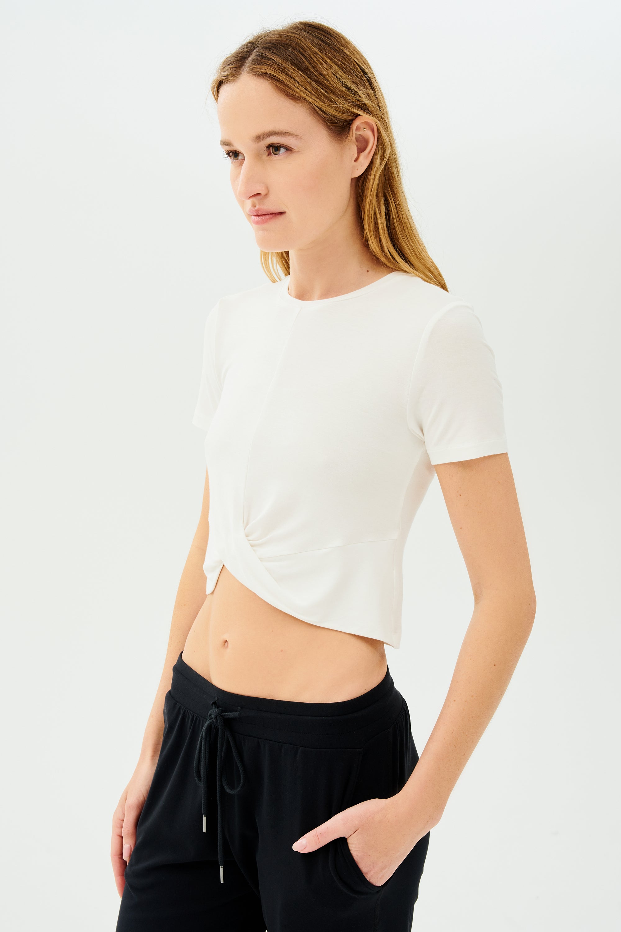The model is wearing a white Daisy Jersey Tee and black high waist leggings by SPLITS59.