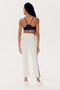A person with long braided hair is standing, facing away. They radiate confident workout vibes in a navy sports bra and high waist SPLITS59 Raquel High Waist Crop - White/Indigo athletic pants made of 4-way stretch supplex fabric. Their white sneakers complete the look, all set against a plain white background.