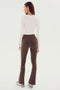 A person is standing and facing away, wearing a white SPLITS59 Louise Rib Long Sleeve Crop, brown flare leggings with a side stripe, and sneakers.