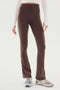 A person wearing SPLITS59 Raquel High Waist Flared Legging in Dark Chocolate with White side stripes, made from 4-way stretch supplex fabric, and running shoes is standing against a white background. Only the lower torso and legs are visible.