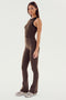 A woman standing in profile is wearing the Raquel High Waist Flared Leggings in Dark Chocolate by SPLITS59, paired with a matching tank top and white sneakers, showcasing the 4-way stretch material.