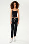 A woman in black pants and a SPLITS59 Loren Seamless Waist Length Tank made of chafe-free fabric.