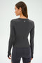 Dressed in an SPLITS59 Airweight Lite LS Waist Length top - Graphite - and shorts, a person stands facing away, ready for workouts.