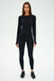 Wearing the SPLITS59 Airweight Lite LS Waist Length in black, paired with airweight leggings, this individual stands against a white background—ideal for intense workouts or everyday comfort.