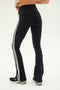 Person wearing SPLITS59 Raquel High Waist Flared Legging in Black/White with white side stripes, a black cropped top, and black sneakers.