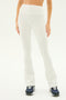 A person is shown wearing the Raquel High Waist Flared Legging in white by SPLITS59, made from 4-way stretch supplex fabric, paired with black athletic shoes. The background is plain white.