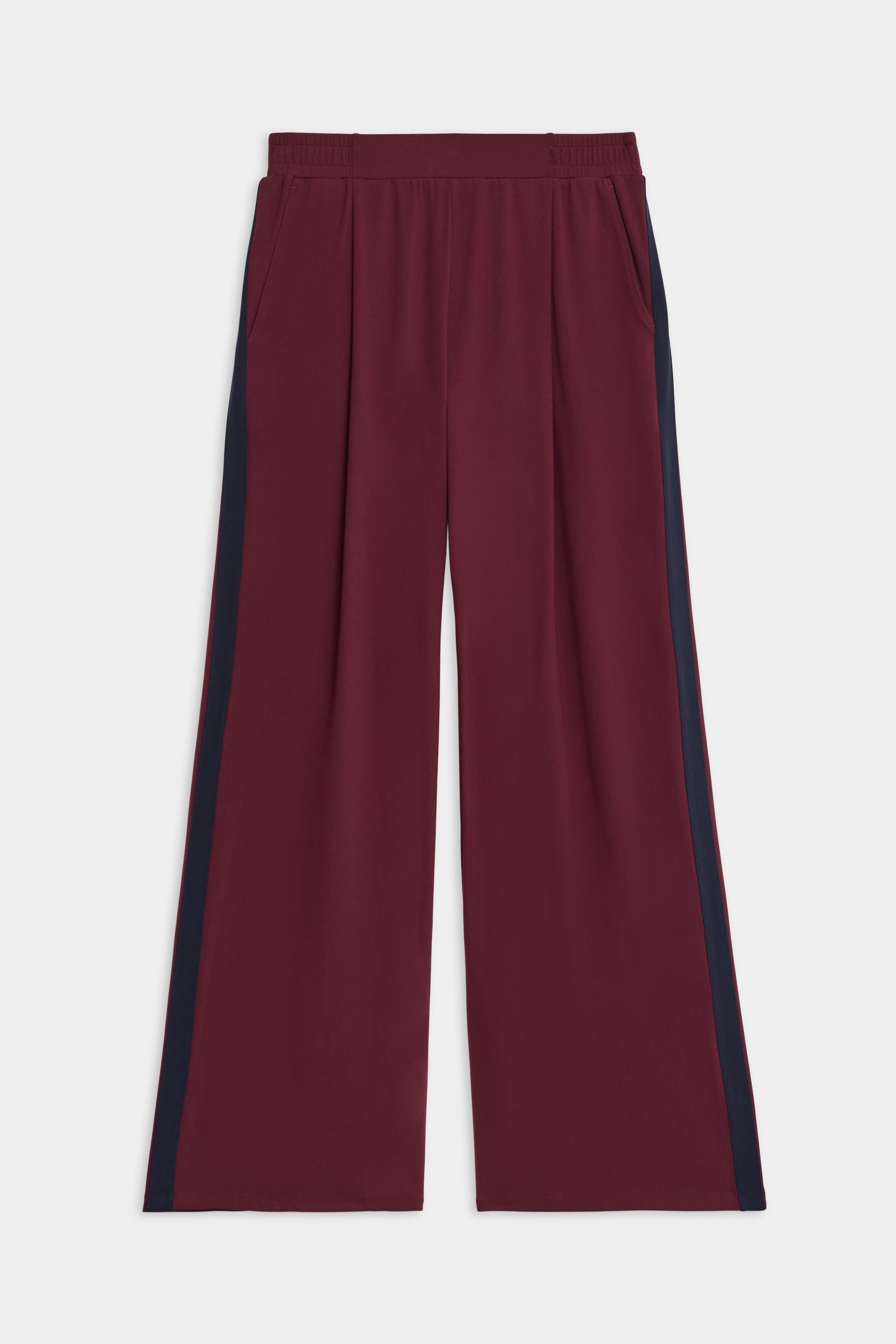 The SPLITS59 Luca Airweight Trouser with Stripe features a wide-leg maroon design, navy side stripes, an elastic waistband, and side pockets, shown laid flat on a white background.