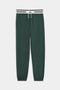 The SPLITS59 Andie Oversized Fleece Sweatpant W/ Stripe features a dark green color with elastic cuffs and a white and black striped drawstring waistband, shown on a plain white background.
