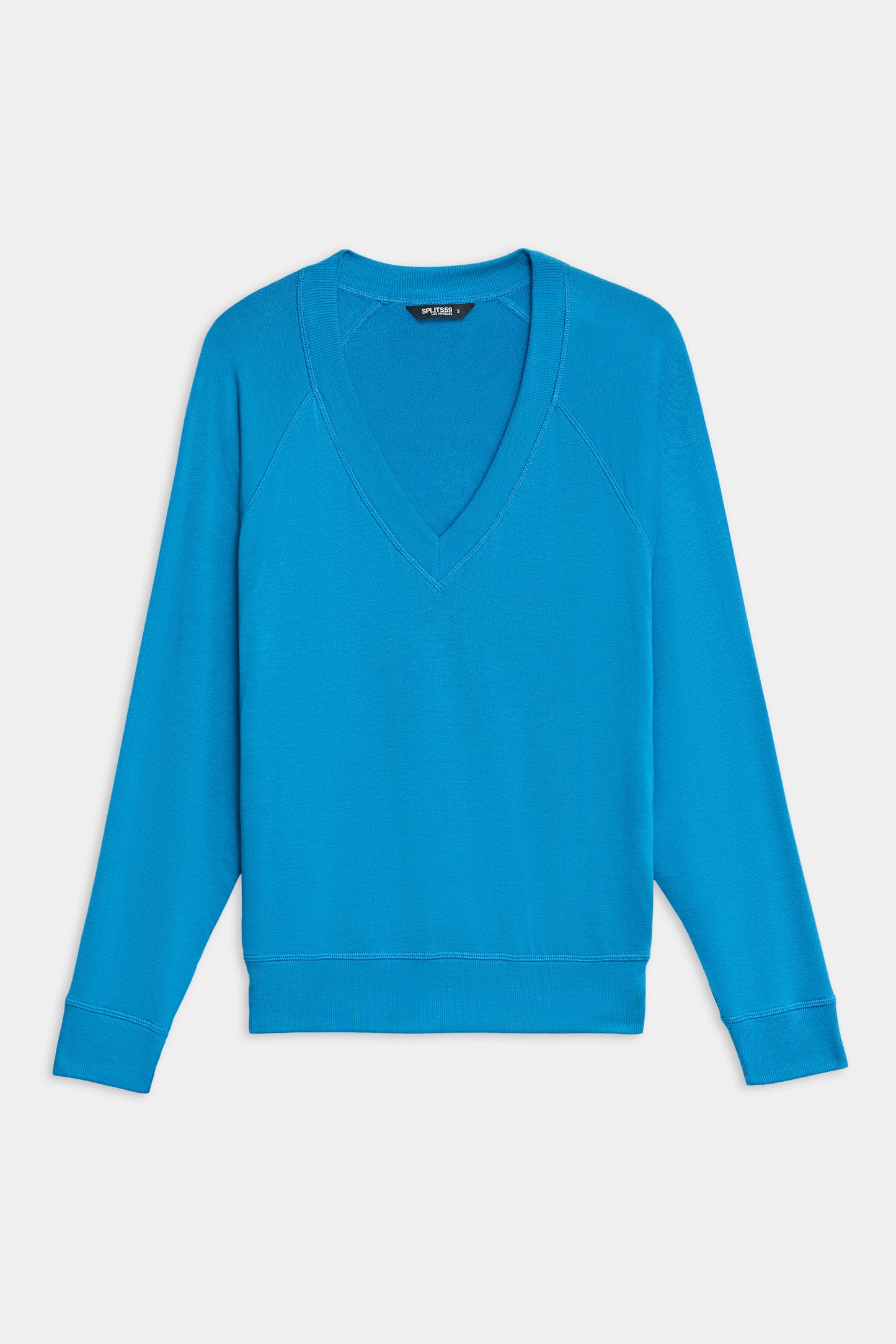 The SPLITS59 Bennie Fleece V-Neck Sweatshirt in bright blue features long sleeves, ribbed cuffs, and a ribbed hem, shown laid flat on a white background.