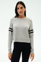 A woman faces forward wearing the SPLITS59 Brooks Stripe Fleece Sweatshirt in heather grey/black with black striped sleeves and black leggings, set against a plain white background.