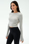 A woman stands against a plain background wearing the SPLITS59 Louise Rib Long Sleeve Crop in Heather Grey and high-waisted black leggings.