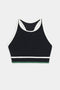 The SPLITS59 Layla Airweight Bra in Black/Arugula, featuring a racerback design with white trim and a green band, is perfect for hot yoga with its lightweight feel.