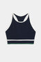 The Layla Airweight Bra by SPLITS59 in indigo with white trim offers a racerback design, ideal for hot yoga. Shown on a plain white background, it seamlessly marries style and functionality.