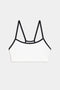 White bralette with thin black straps and black trim, displayed on a plain light gray background.
