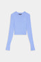 A light blue, long-sleeve, crew neck cropped top is laid flat on a white background.