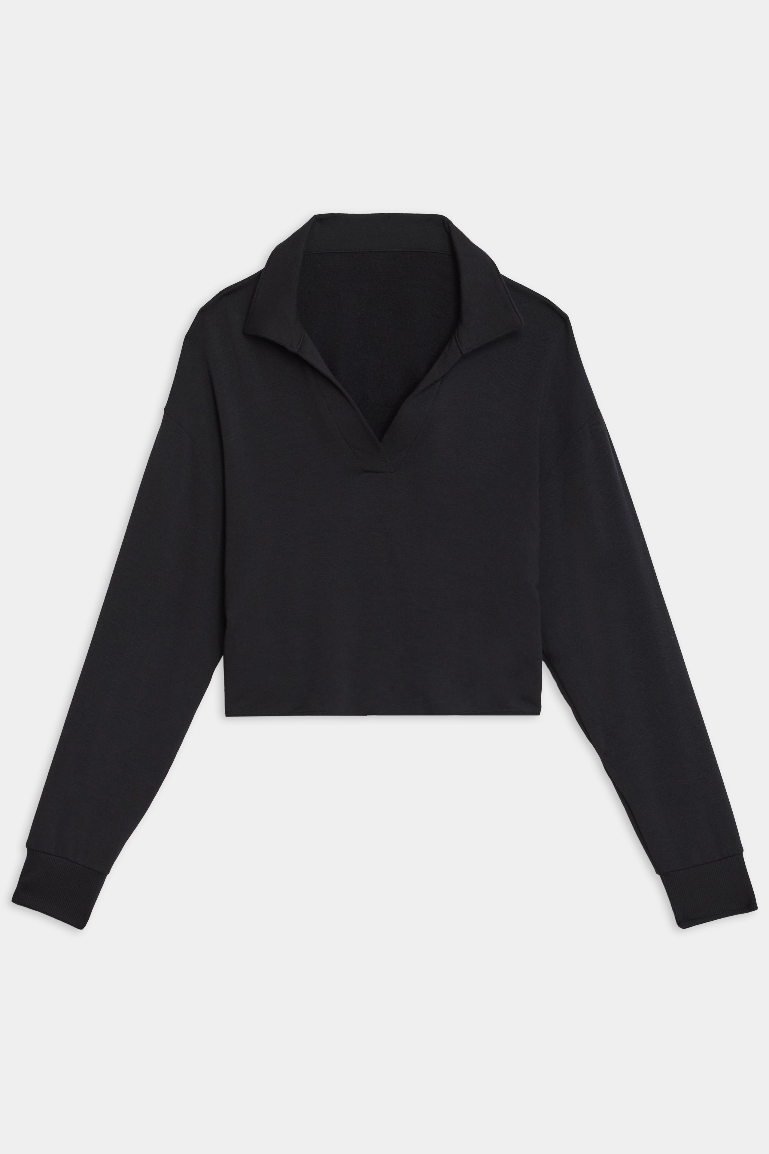 The Joan Fleece Polo Sweatshirt in black by SPLITS59 is a long-sleeve collared crop top made from stretch modal fabric, set against a white background.